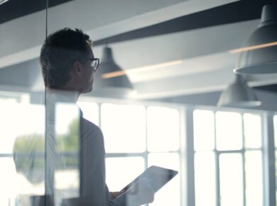 Formal man with tablet giving presentation in office